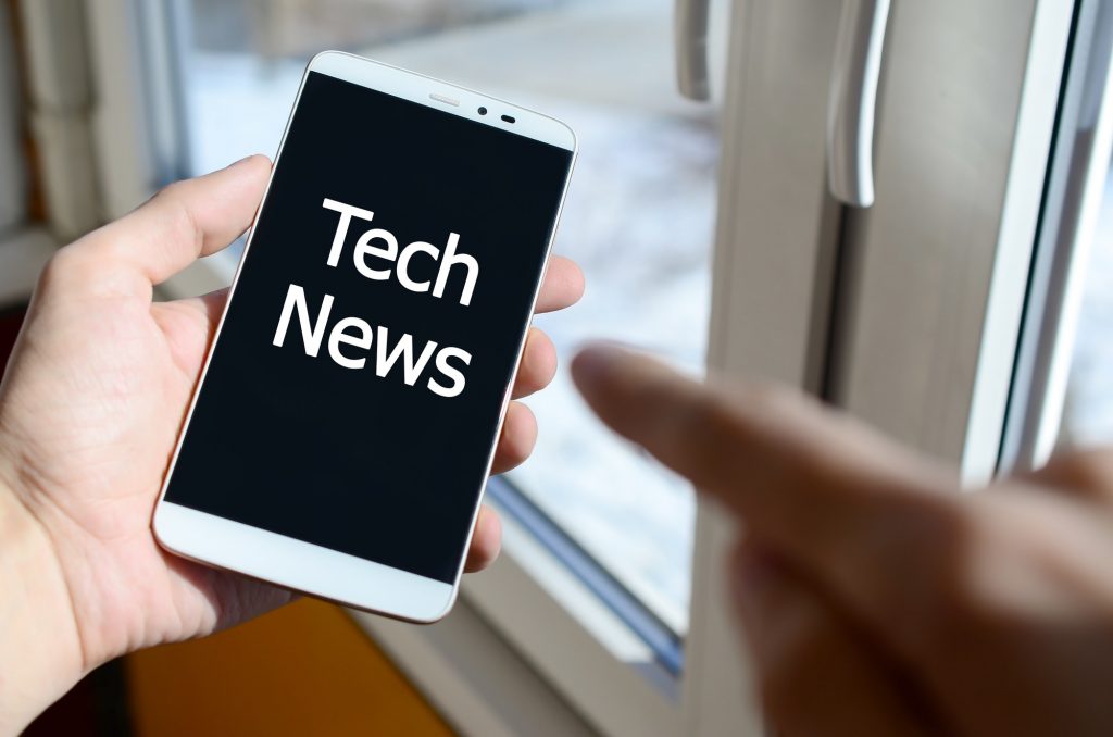 A person sees a white inscription on a black smartphone display that holds in his hand. Tech news